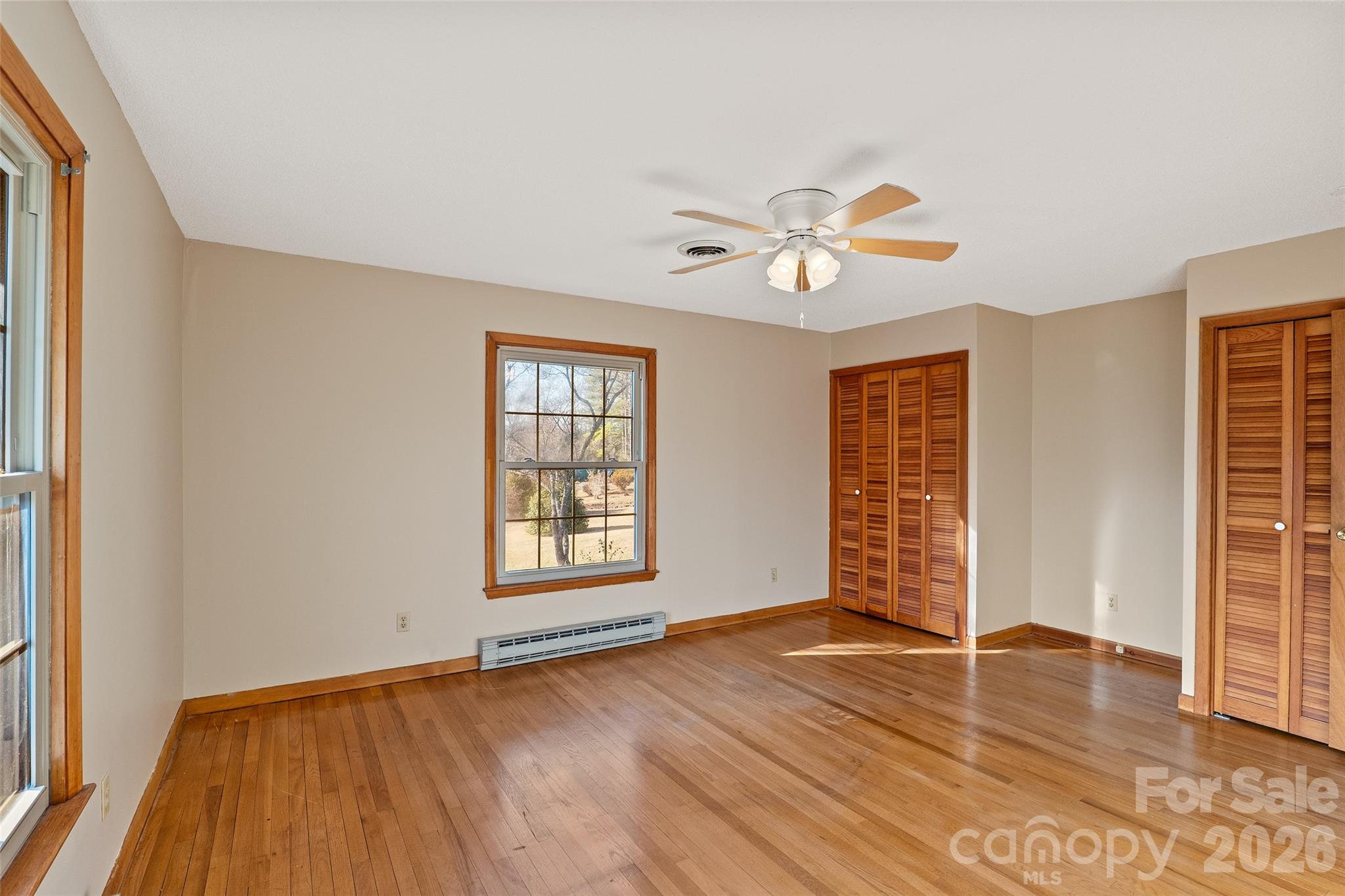591 Landrum Road Tryon, NC 28782 - Photo 28 of 48 an empty room with wooden floor and windows