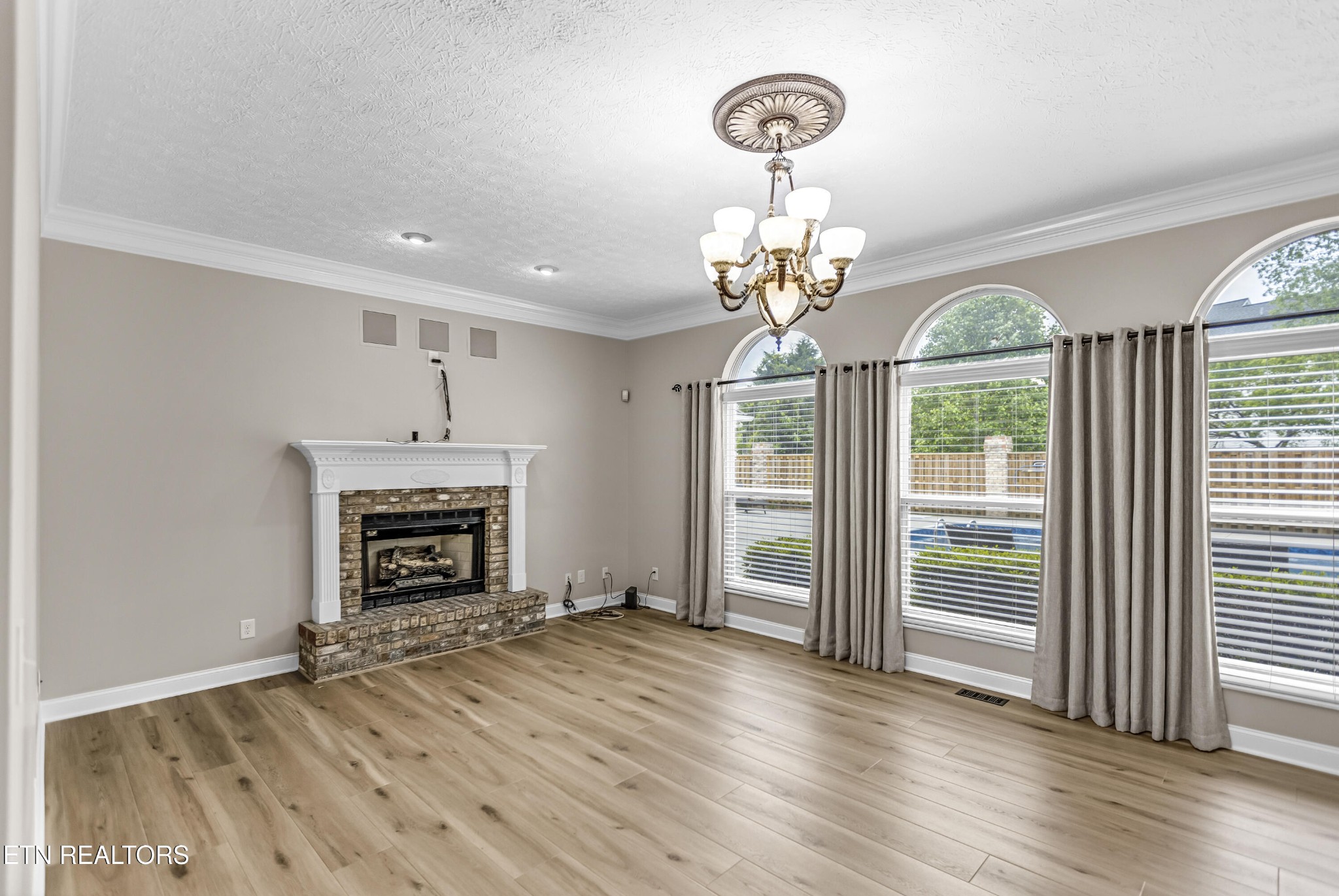 117 Mayview Drive Powell, TN 37849 - Photo 8 of 56 an empty room with wooden floor fireplace and windows
