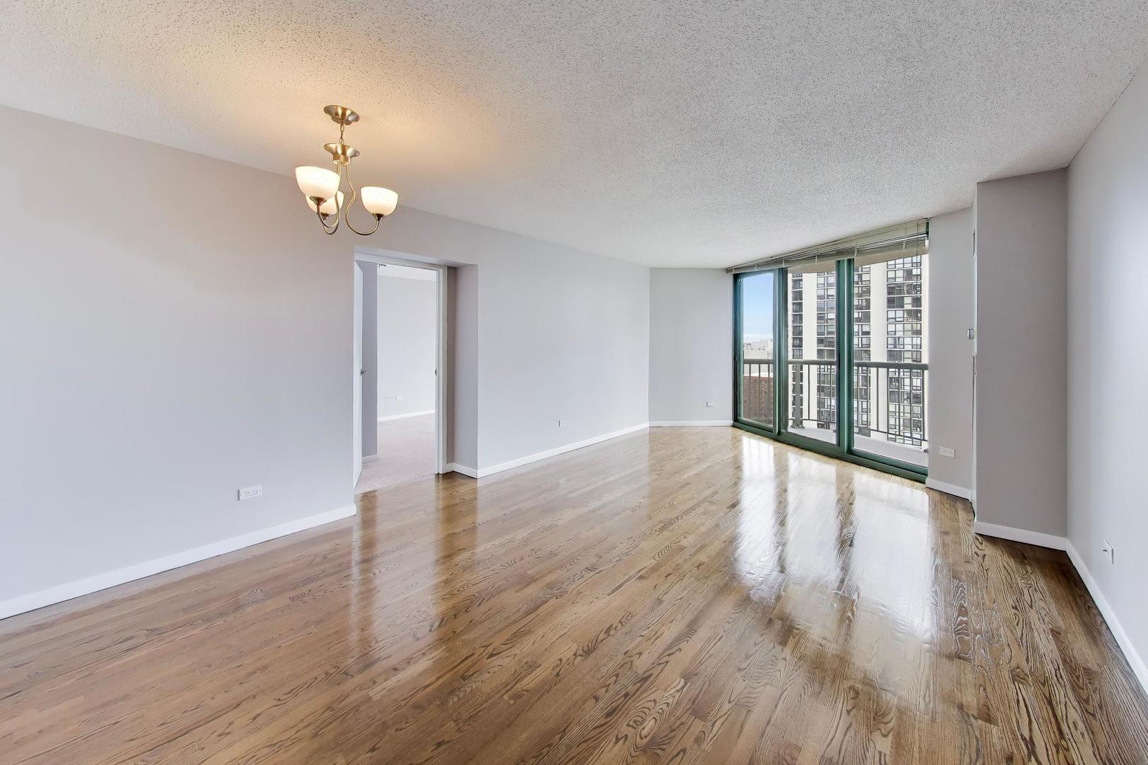 111 West Maple Street, Unit 1503 Chicago, IL 60610 - Photo 12 of 39 an empty room with wooden floor and windows