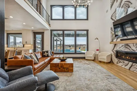 a kitchen with stainless steel appliances granite countertop a dining table chairs sink and cabinets
