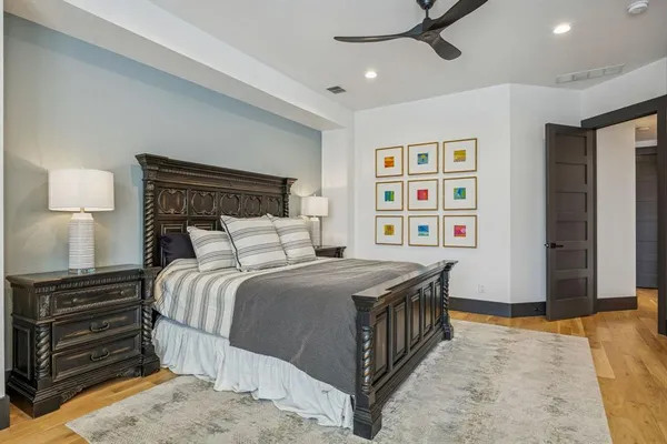 a bedroom with a bed and a flat tv screen on dresser