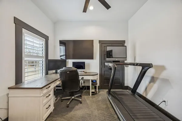 a view of a workspace with furniture and a window