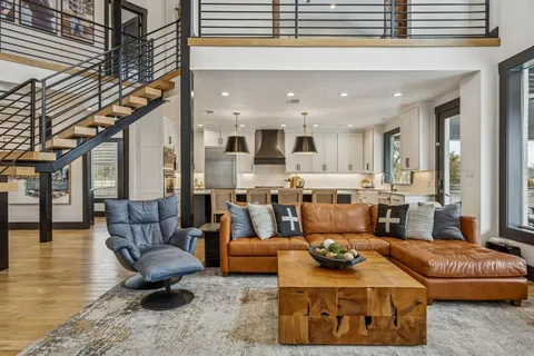 a living room with furniture kitchen view and a wooden floor