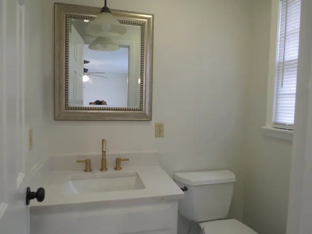 a bathroom with a toilet sink and mirror