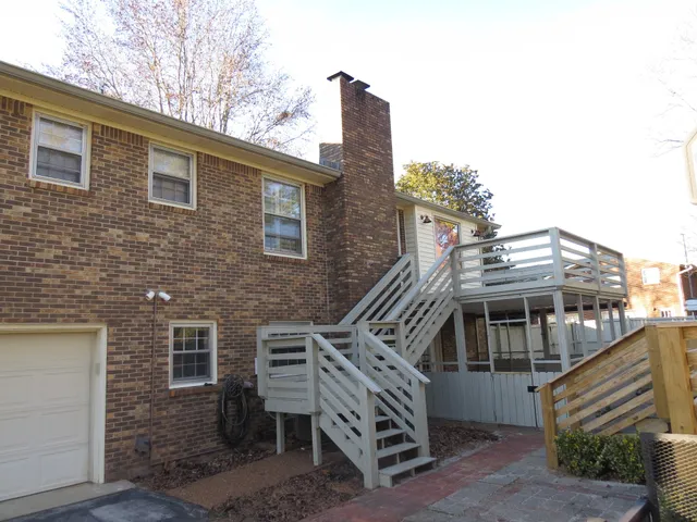 a view of a house with a deck and furniture