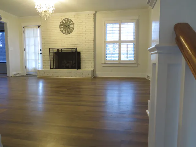 an empty room with wooden floor and a window