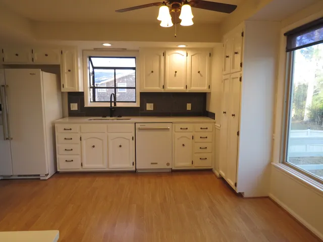 a kitchen with granite countertop a stove a sink and a refrigerator