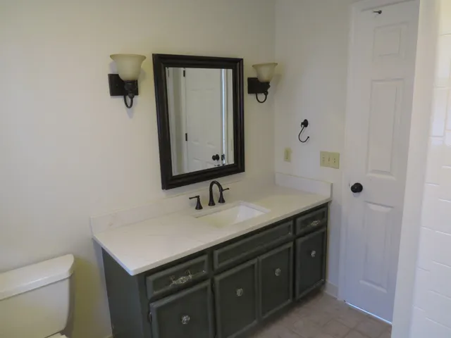 a bathroom with a toilet sink and mirror