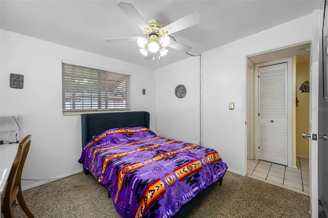 a bedroom with a bed and a flat tv screen on wall