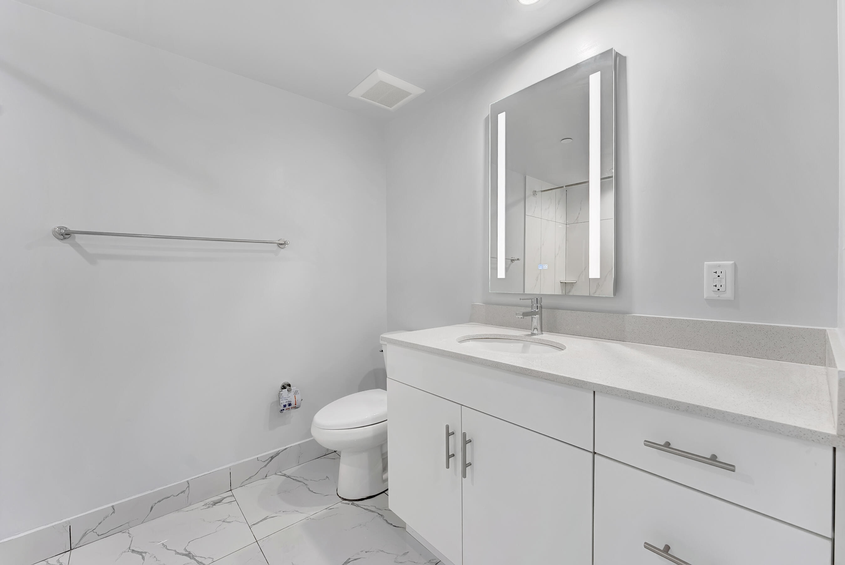250 West Hidden Valley Boulevard, Unit 3 Boca Raton, FL 33487 - Photo 17 of 27 a bathroom with a granite countertop sink a toilet and a mirror