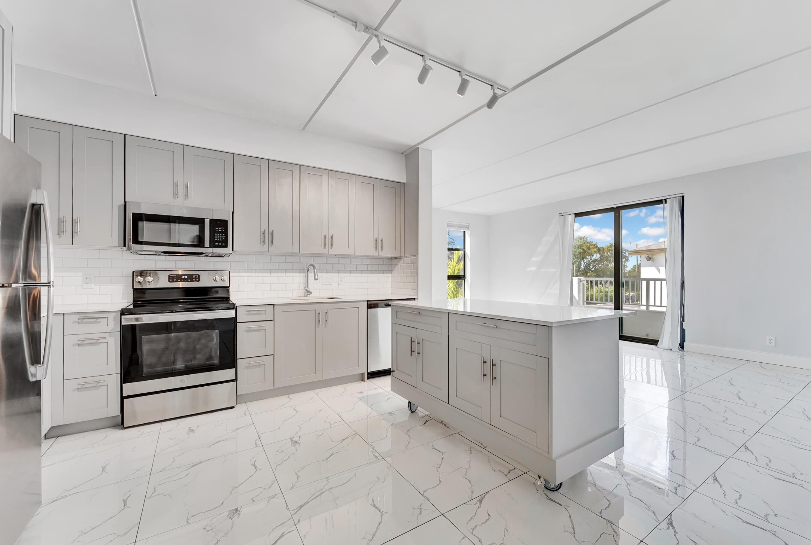 250 West Hidden Valley Boulevard, Unit 3 Boca Raton, FL 33487 - Photo 3 of 27 a kitchen with white cabinets and appliances