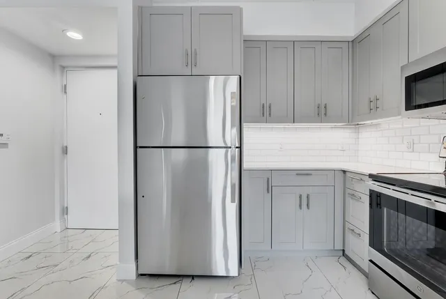 a kitchen with cabinets and stainless steel appliances
