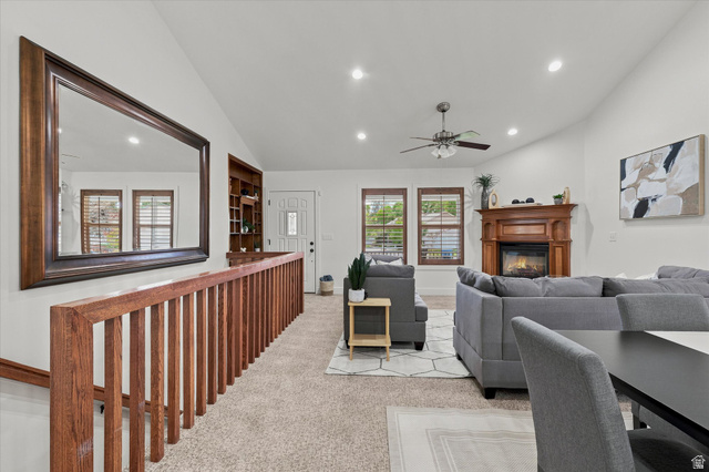 689 Apple Drive Logan, UT 84321 - Photo 4 of 52 Spacious living area featuring vaulted ceilings, recessed lighting, a fireplace with a decorative wood mantel, and multiple windows with wood blinds