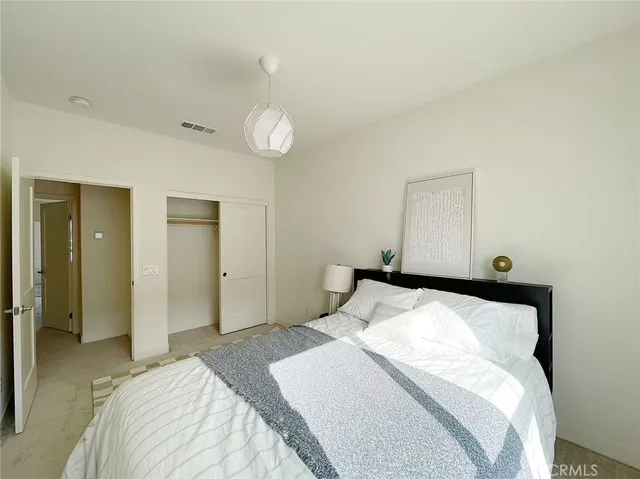 a bedroom with a bed and a large mirror