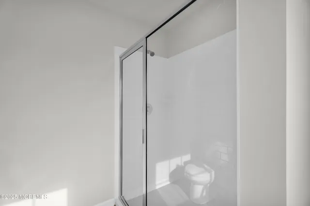 a bathroom with a bathtub shower sink vanity mirror and toilet