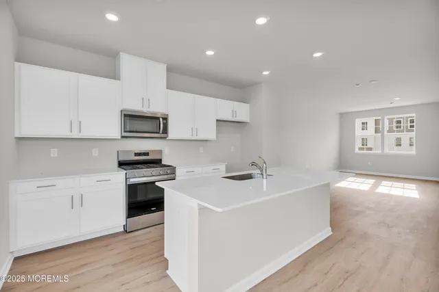 a kitchen with white cabinets stainless steel appliances and sink