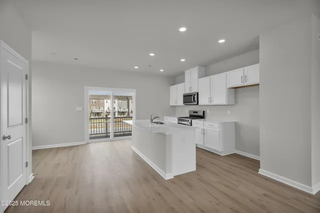 a kitchen with a white wooden cabinets and white stainless steel appliances
