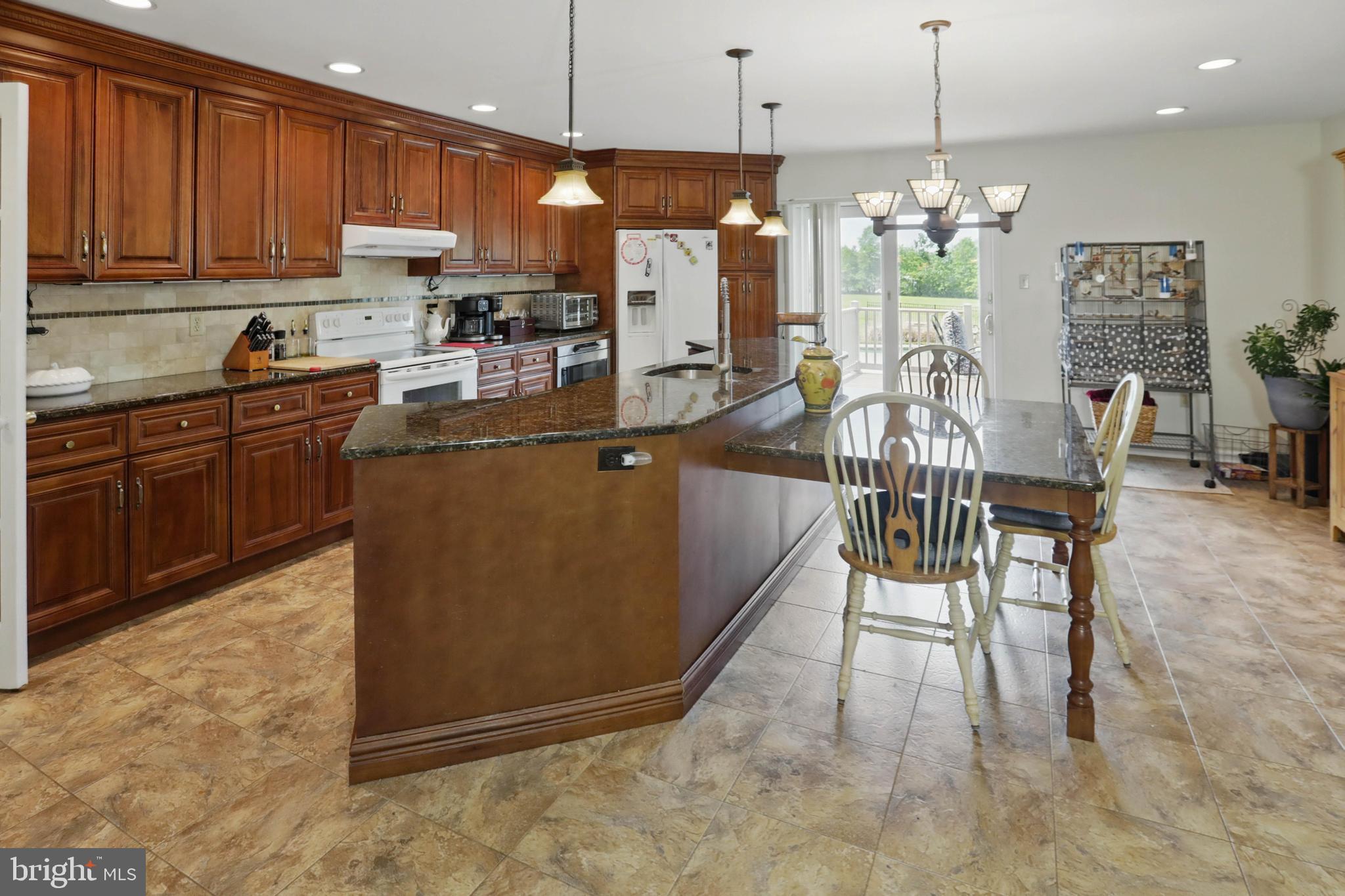 3494 Finland Road Pennsburg, PA 18073 - Photo 8 of 63 a kitchen with granite countertop a table chairs microwave and cabinets