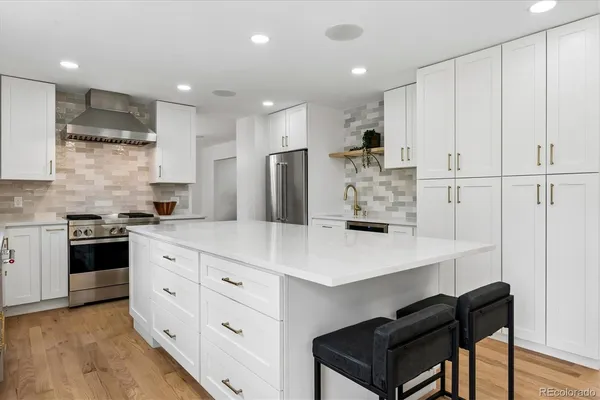 a kitchen with white cabinets and stainless steel appliances