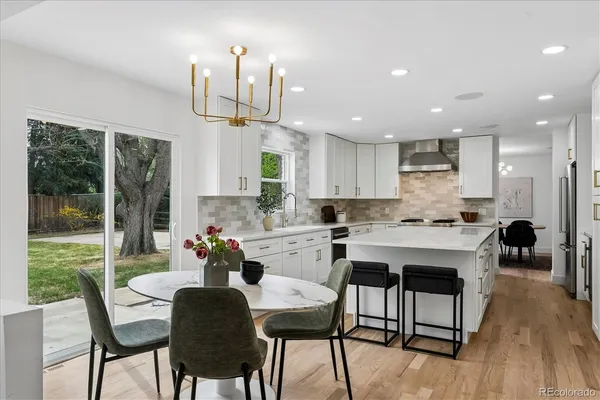 a kitchen with a dining table chairs and refrigerator