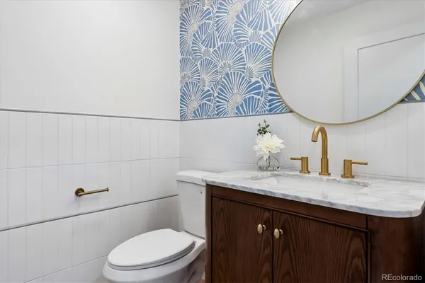 a bathroom with a granite countertop sink a toilet and a mirror