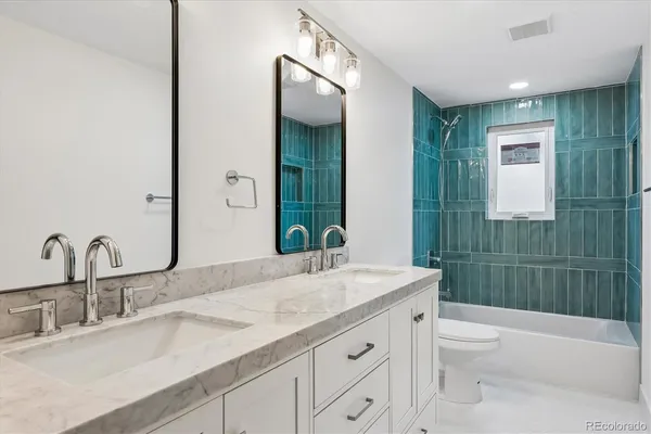 a bathroom with a granite countertop sink a toilet and shower