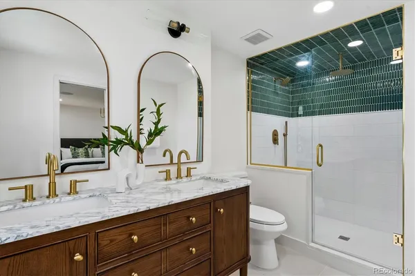 a bathroom with a granite countertop sink a toilet and mirror