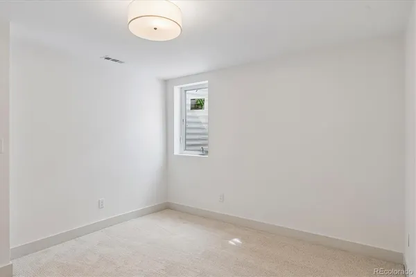an empty room with a fan and a window