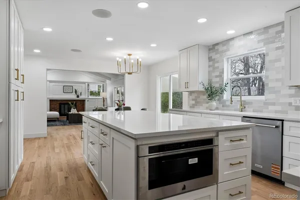 a kitchen with stainless steel appliances granite countertop a sink a stove and a wooden floors