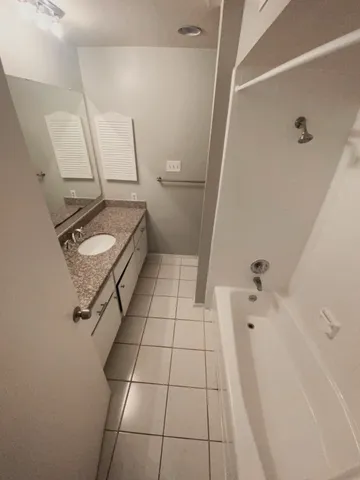 a view of a refrigerator in kitchen and an empty room