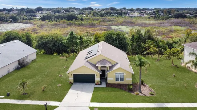 a aerial view of a house next to a lake with a yard