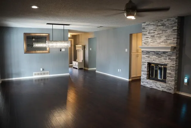 a view of empty room with wooden floor and fireplace