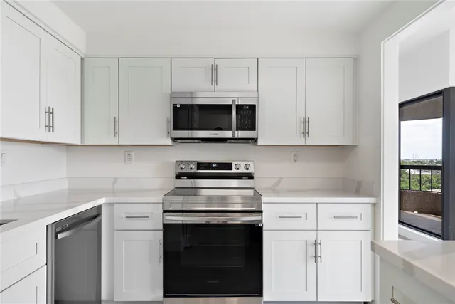 a kitchen with white cabinets and stainless steel appliances