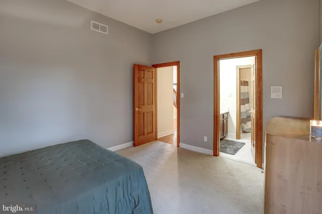 a bedroom with a large bed and a mirror