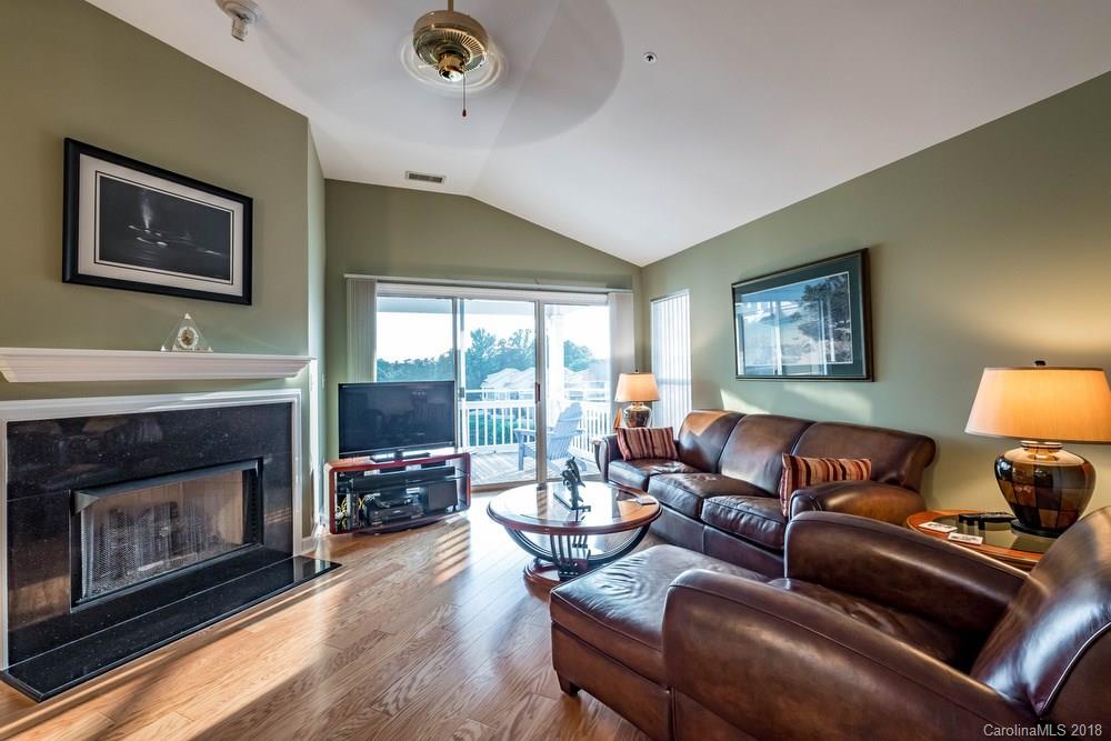 1115 Torrence Circle, Unit 63 Davidson, NC 28036 - Photo 6 of 23 a living room with furniture a fireplace and a large window