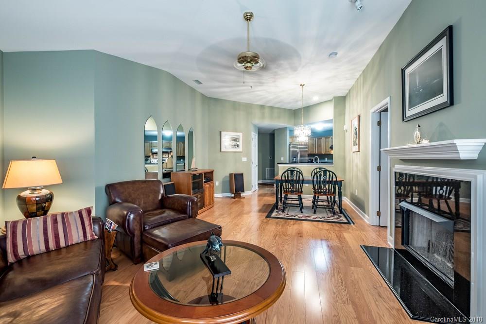 1115 Torrence Circle, Unit 63 Davidson, NC 28036 - Photo 7 of 23 a living room with furniture a fireplace and a chandelier