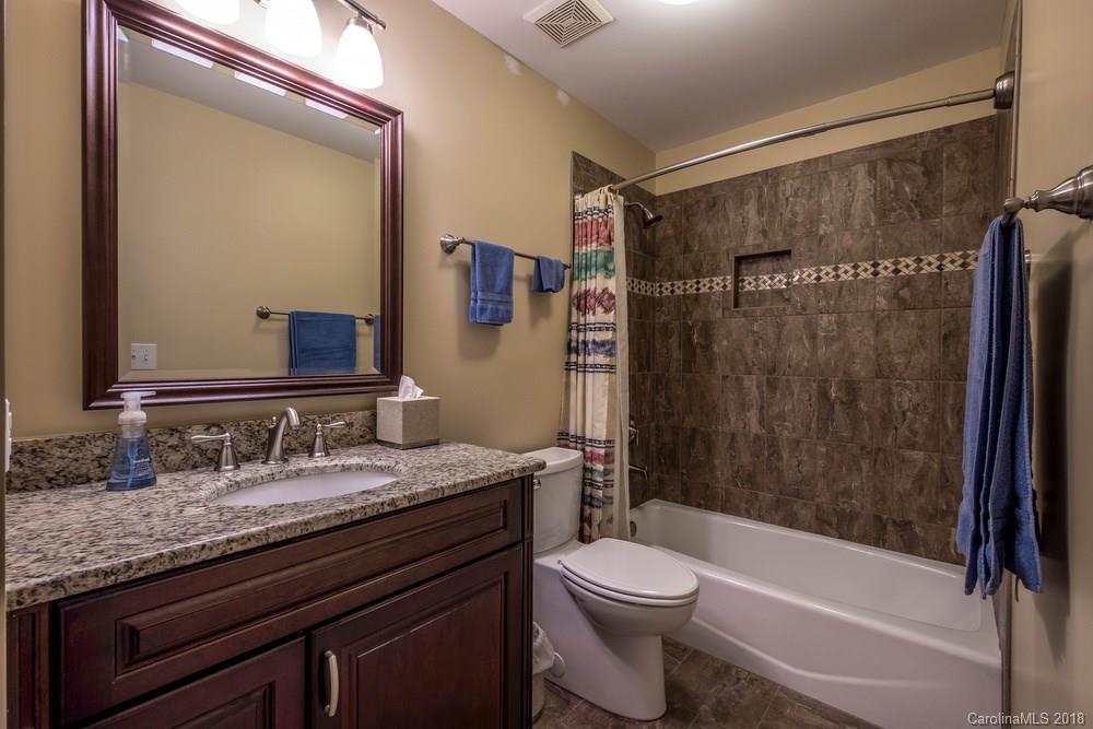 1115 Torrence Circle, Unit 63 Davidson, NC 28036 - Photo 10 of 23 a bathroom with a granite countertop sink toilet and shower