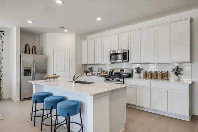 a kitchen with appliances a sink cabinets and a counter top space