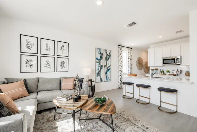 a living room with furniture and a dining table with kitchen view