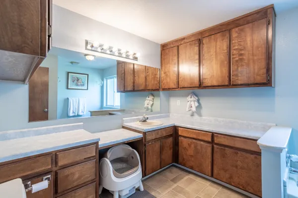 a kitchen with a sink a stove cabinets and wooden floor