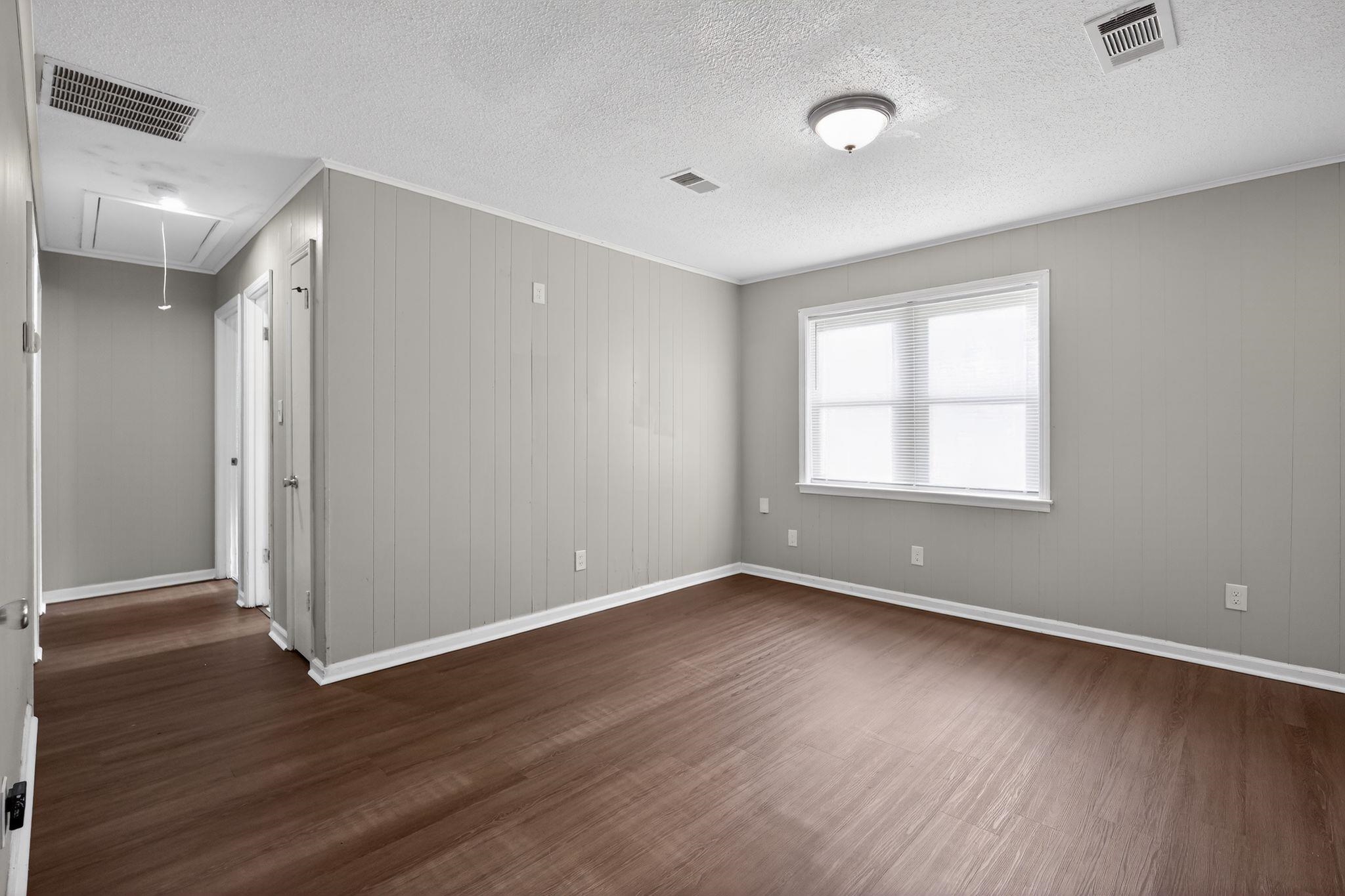 4686 Gill Road Memphis, TN 38109 - Photo 13 of 32 Spacious room featuring wood-finish flooring and light gray paneling