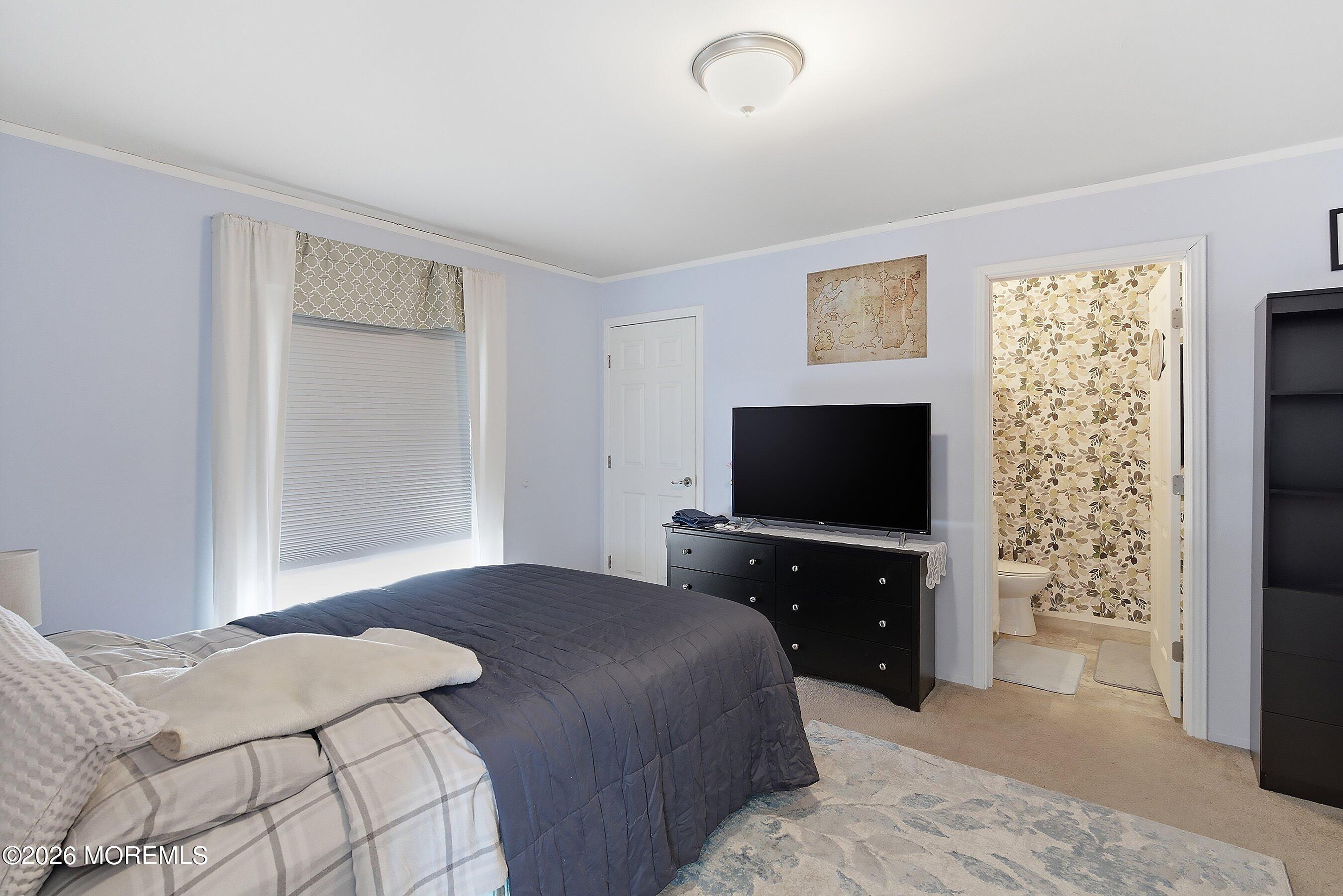511 Sykesville Road, Unit 116 Wrightstown, NJ 08562 - Photo 4 of 14 a bedroom with a bed and a flat screen tv