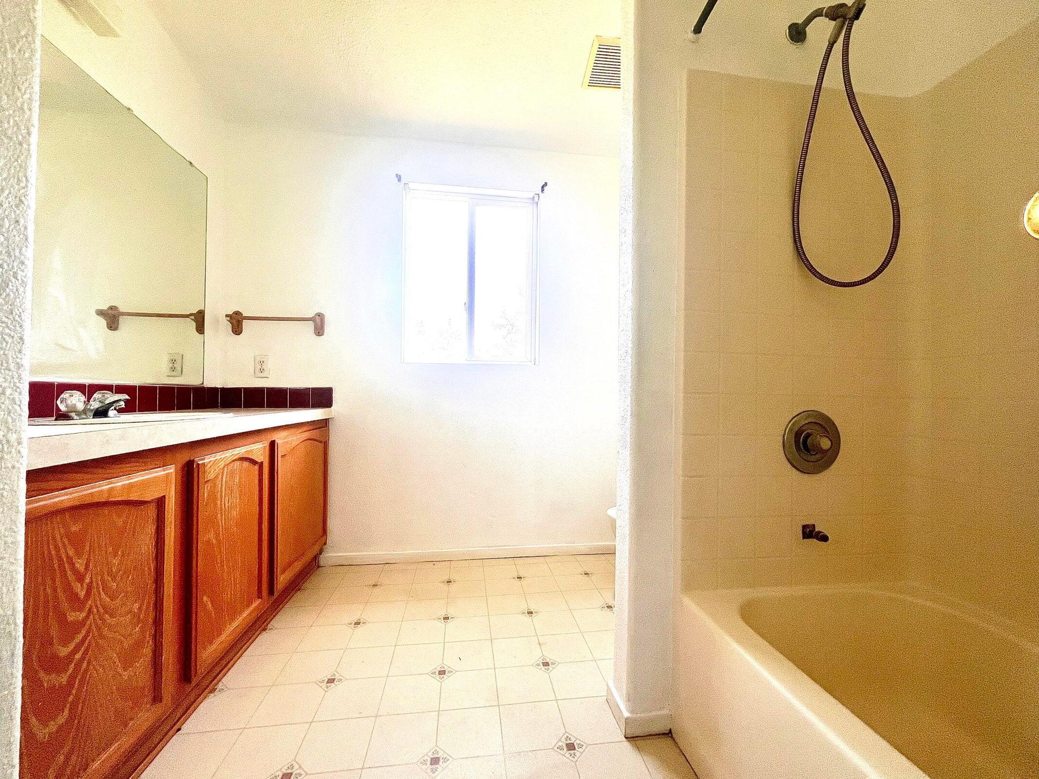 5321 Pine Street Anderson, CA 96007 - Photo 47 of 49 a bathroom with a granite countertop sink a mirror and a bathtub