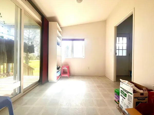 a view of dining room with kitchen island stainless steel appliances wooden floor and window