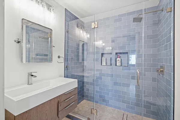 a bathroom with a sink shower and a mirror