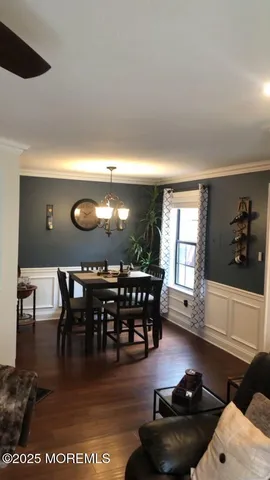a view of dining room and livingroom with furniture wooden floor a rug and a chandelier