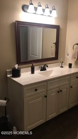 a bathroom with a sink vanity and a mirror