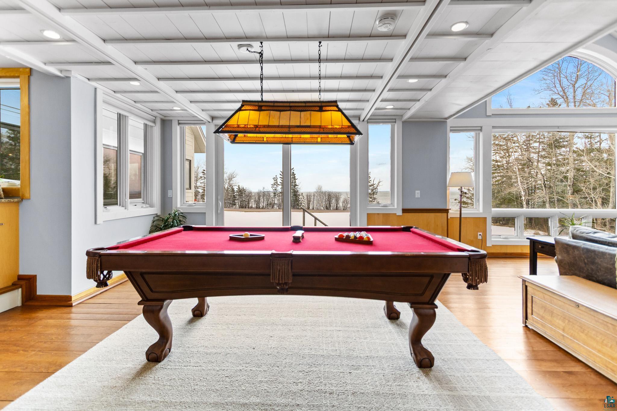 5163 Greenwood Road Duluth, MN 55804 - Photo 7 of 10 Spacious recreation area featuring a coffered ceiling with recessed lighting, wood-finish flooring, and expansive windows offering a forest backdrop