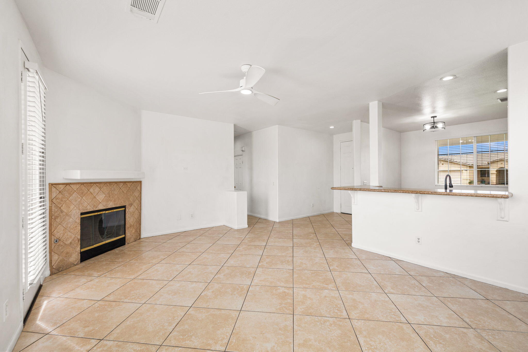 47558 Bison Circle Indio, CA 92201 - Photo 12 of 38 a view of an empty room and kitchen with fireplace cabinet