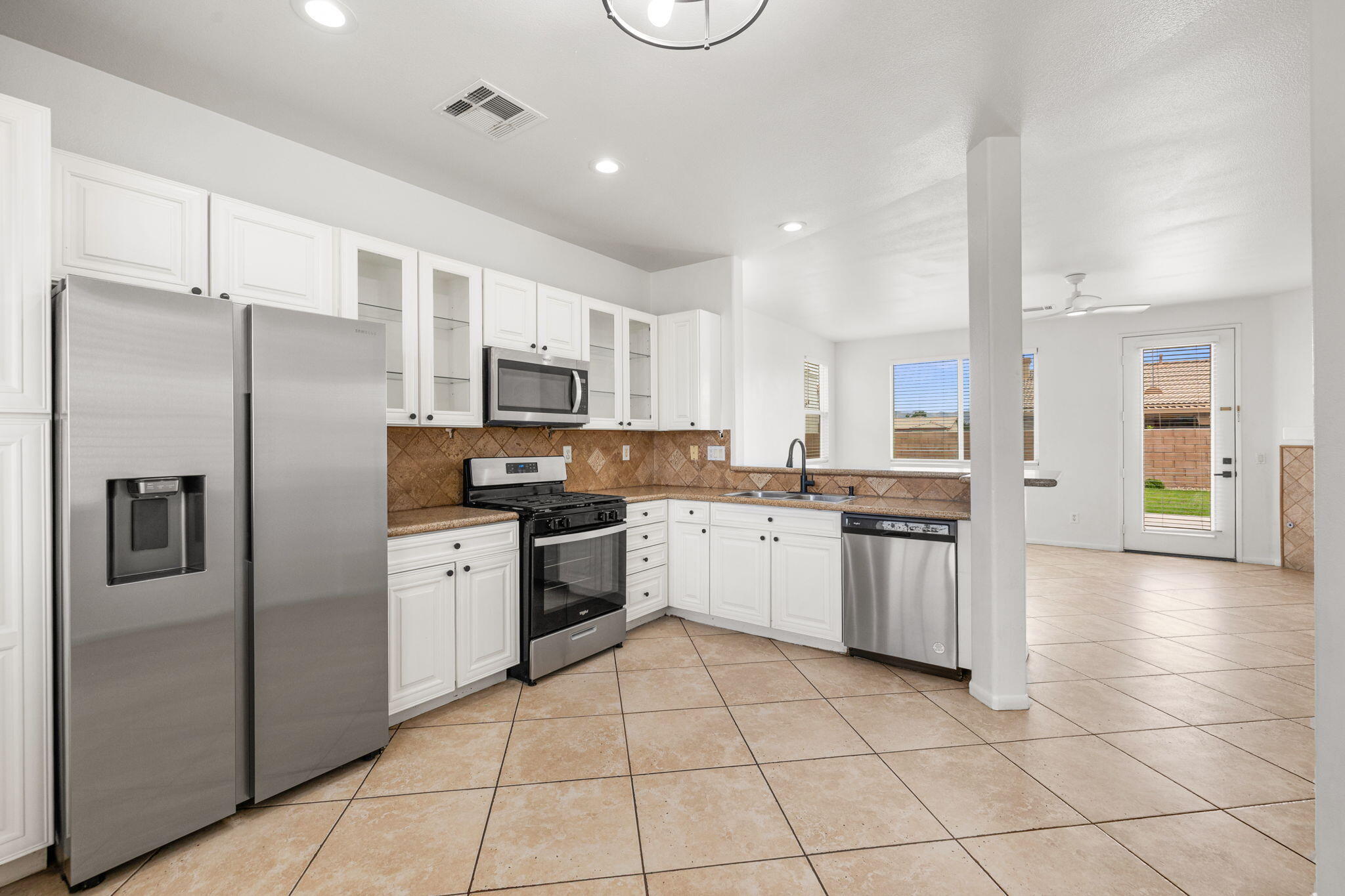47558 Bison Circle Indio, CA 92201 - Photo 9 of 38 a kitchen with granite countertop a refrigerator a sink and white cabinets